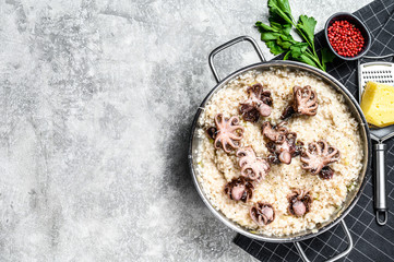 Italian Risotto with octopus and mushrooms. Gray background. Top view. Space for text