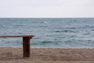 Un banco de madera en la arena mirando el horizonte