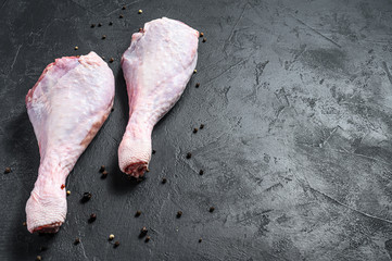 Raw turkey thigh with spices. Black background. Top view. Space for text