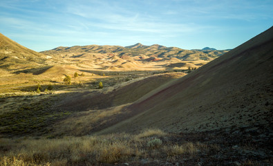 Incredible gold and red hills of clay fossil beds in a semi desert mountain valley on a sunny day of the painted cove trail at the john day fossil beds in Oregon