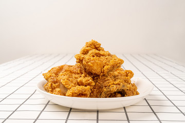 Close Up Fried Chickens on white Plate Isolated on table. Look Yummy and Yellow Gold Color.
