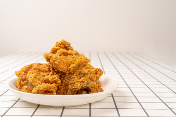 Close Up Fried Chickens on white Plate Isolated on table. Look Yummy and Yellow Gold Color.