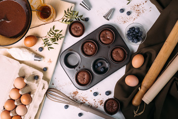 cupcakes with cream and blueberries on kitchen table