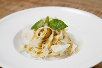 pasta with cheese on a plate on a wooden background