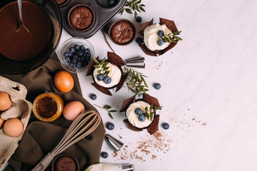 Fototapeta na wymiar cupcakes with cream and blueberries on kitchen table