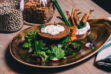 Close up healthy fresh salad with fried fish and with whole grain bread. Healthy organic dish.