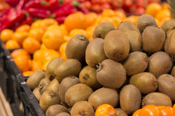 Naklejka na ściany i meble Fruits and vegetables at market. Kiwi, tangerines and peppers