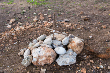 Small roadside pet grave with pile of boulders and simple handmade wood cross, Havana, Cuba