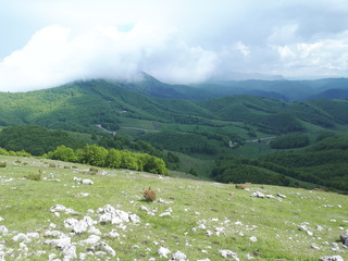 Fototapeta na wymiar Mountain covered with clouds on early summer day