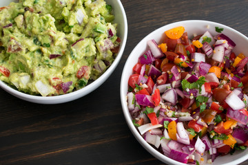 Bowls of Guacamole and Pico de Gallo: Two white bowls filled with freshly made guacamole and pico de gallo (salsa fresca)