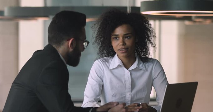Young african ethnicity office worker nodding, agreeing with arabian coworker.