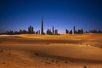 Skyline de Dubaï avec dunes de sable et coucher de soleil dans le désert