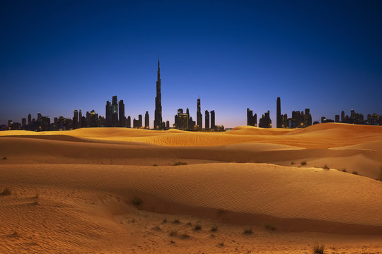 Dubai skyline with sand dunes and desert sunset