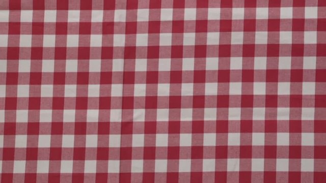While the wooden table is covered by the red-white checkered tablecloth, the top view. Stock Video