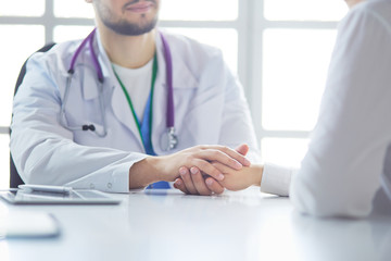 Fototapeta premium Close-up of stethoscope and paper on background of doctor and patient hands