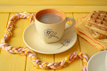 a yellow cup of latte, cappuccino coffee with milk, coffee, round ceramic orange cup and plate