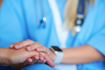 Obraz premium Woman doctor helping senior holding hand in hospital