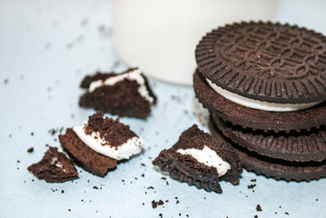 Delicious sandwich cookies with a glass of milk. Gluten-free cornmeal cookies, black.  healthy eating concept, flat lay White background
