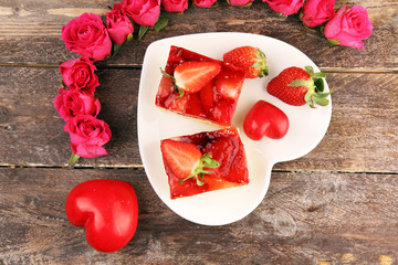 strawberry cake and many fresh strawberries on rustic table with hearts and roses for valentines day.