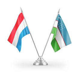 Uzbekistan and Luxembourg table flags isolated on white 3D rendering