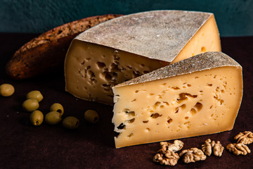 Cheese, bread and nuts on a dark background