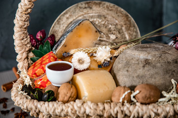 Basket with cheese, honey and grapes on a blue background