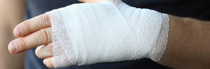 Male hand with tight elastic bandage on arm closeup. Self help sprain concept