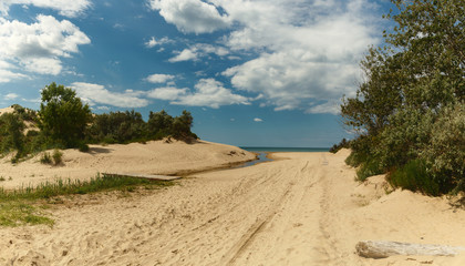 Fototapeta na wymiar the road across the sand to the sea, the path through the sand dunes to the ocean