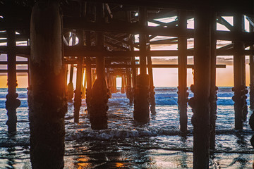 under the pier at sunset