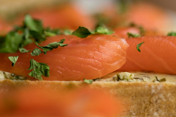 Close-up of trout lying on a slice of bread decorated with chopped parsley