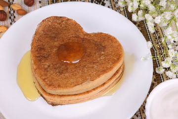 Homemade Sweet Banana oat Pancakes with fresh sour cream and jam on a white plate on ethnic tablecloth. Healthy diet recipe breakfast or brunch, traditional, closeup