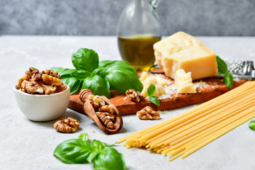 spaghetti pasta pesto Italy food. ingredients for traditional Italian pasta with pesto : spaghetti, fresh Basil, nuts, Parmesan cheese and olive oil. recipe Italian cuisine. selective focus