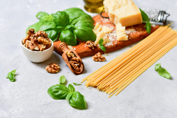 spaghetti pasta pesto Italy food. ingredients for traditional Italian pasta with pesto : spaghetti, fresh Basil, nuts, Parmesan cheese and olive oil. recipe Italian cuisine. selective focus