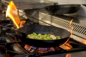 Brussel sprouts being fried over an open flame