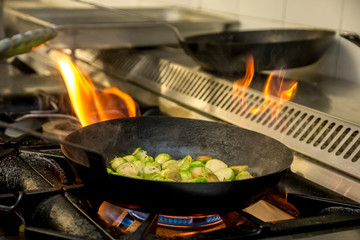 Brussel sprouts being fried over an open flame