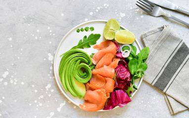 keto diet salmon and avocado salad with arugula and lime. on a white plate. healthy lunch. ketogenic diet  food 