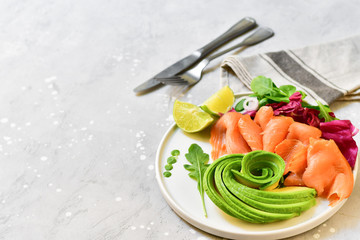 keto diet salmon and avocado salad with arugula and lime. on a white plate. healthy lunch. ketogenic diet  food 