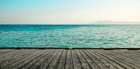 Fototapeta premium gray wooden deck of pier and blue summer sea with sky