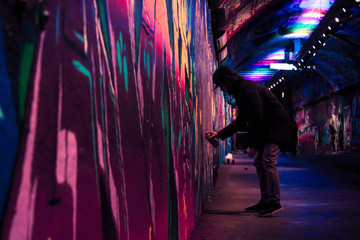 Fototapeta na wymiar Artist spraypainting wall - The Vaults, London