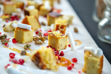cake squares on a wooden board with chocolate and berries