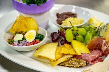 cheese and cold meat board with grapes and bread