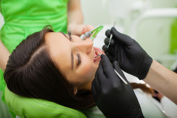 Dentist are treating teeth to client in dental office