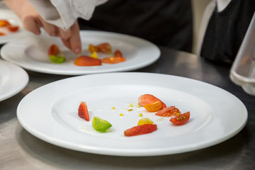 plating a dish with tomatos 