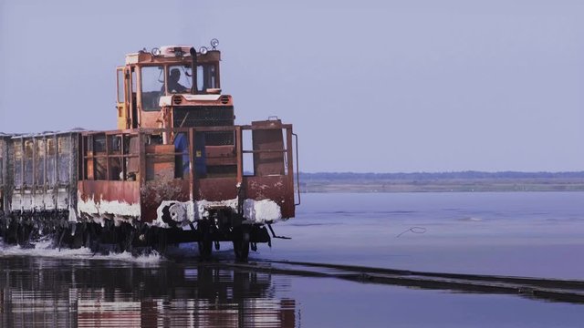 Old train rides on the railway laid in the water through the salt lake. train travels from water. Mined salt in Lake Burlin. Altai. Bursol. Russia. August 2019 