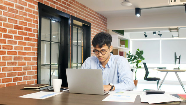 Young asian businessman concentrate on working with laptop computer at office, Asian office man comtemplate on laptop, Asia male business people and office lifestyle concept