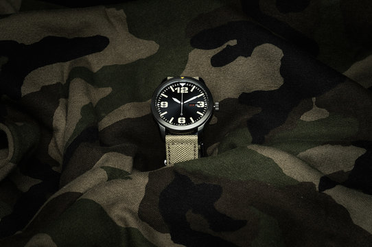 Reloj estilo militar sobre fondo obscuro