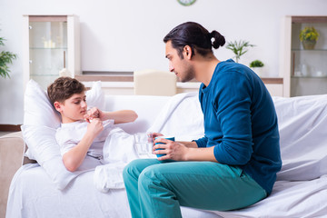 Fototapeta premium Young father caring for sick son