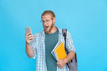 Bearded excited young man student hipster blogger glasses wow emotion hold modern smart phone read...