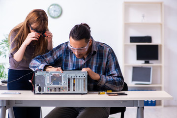 Two repairmen repairing desktop computer