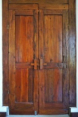 Vintage hand built hardwood door with rich antique patina in a dark room